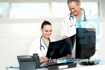 Physicians Reviewing Patients X-ray Report Stock Photo