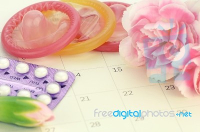 Pills And Condom On Carlendar Background With Soft Light Stock Photo