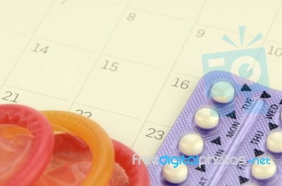 Pills And Condom On Carlendar Background With Soft Light Stock Photo