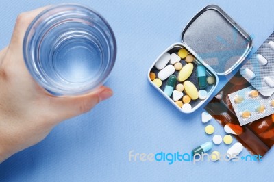 Pills With Hand Holding Drinking Water Stock Photo