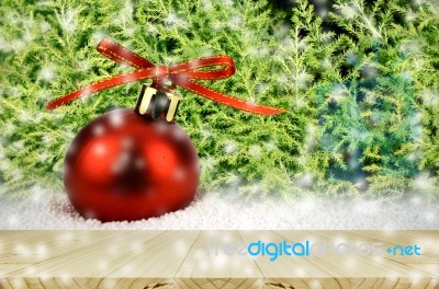 Pine Wood Table And Red Christmas Ball On Snow With Christmas Tree Stock Photo