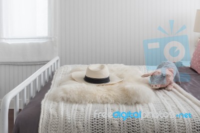 Pink Doll On White Wooden Bed And Classic Hat Stock Photo