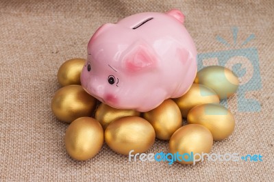 Pink Piggy Bank Climb On Heap Of Golden Easter Egg Stock Photo