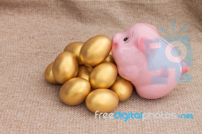 Pink Piggy Bank Climb On Heap Of Golden Easter Egg Stock Photo