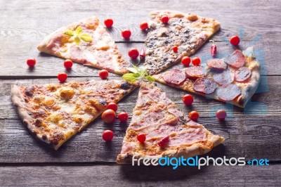 Pizza Cuts And Cherry Tomatos On Wooden Table Stock Photo