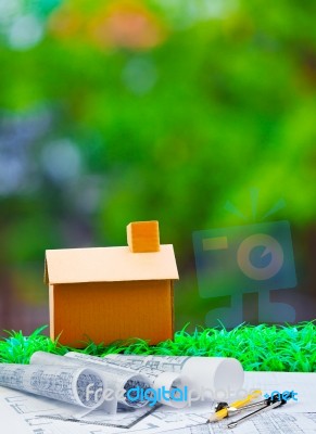 Plan Compass And Paper Work With Home On Green Grass With Blur B… Stock Photo