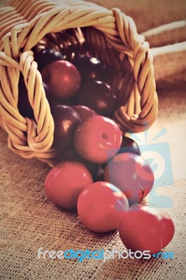 Plumms Scattered From Wicker Basket Stock Photo