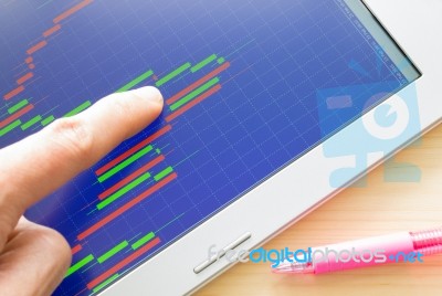 Pointing Stock Or Forex Graph Or Candlestick Chart On Blue Screen And Pink Pen Stock Photo