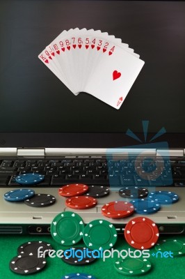 Poker Chips And Cards And A Laptop On Casino Baize Stock Photo