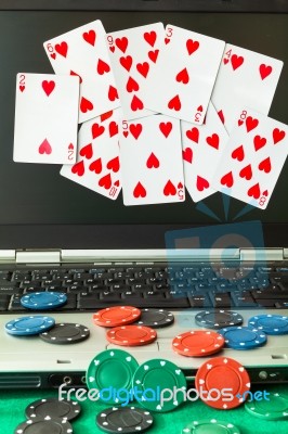 Poker Chips And Cards And A Laptop On Casino Baize Stock Photo