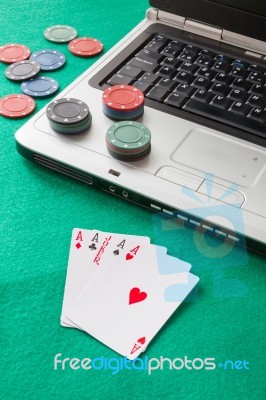 Poker Chips And Cards And A Laptop On Casino Baize Stock Photo