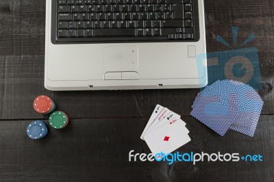 Poker Chips And Cards And A Laptop On Wooden Background Stock Photo