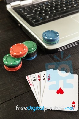 Poker Chips And Cards On A Laptop On Wooden Background Stock Photo