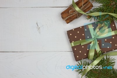 Polka Dot Gift With Christmas Decoration With Cinnamon And Pine Branches On White Wood Background Stock Photo