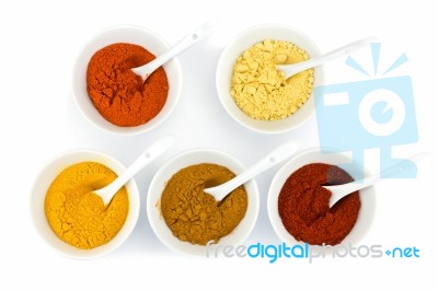 Porcelain Bowls With Various Herbal Spices On White Background Stock Photo