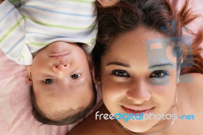 Portrait Of A Beautiful Hispanic Happy Mother With Baby Lying Do… Stock Photo