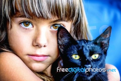 Portrait Of A Beautiful Little Girl Holding A Black Cat Stock Photo