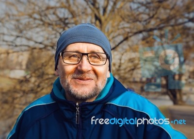 Portrait Of A Smiling Elderly Man Wearing Glasses, A Gray Hat An… Stock Photo