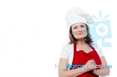 Portrait Of A Smiling Female Chef, Hands Clasped Stock Photo