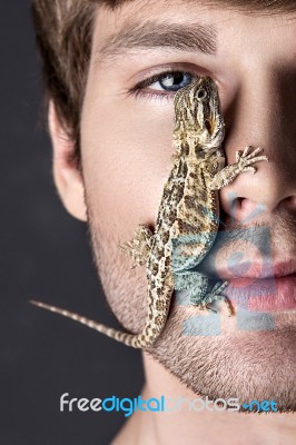 Portrait Of A Young Handsome Man With Lizard On His Face Stock Photo