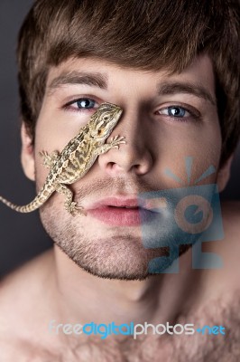 Portrait Of A Young Handsome Man With Lizard On His Face Stock Photo