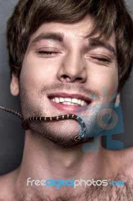 Portrait Of A Young Handsome Man With Snake On His Face Stock Photo