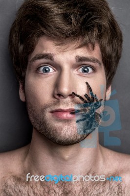 Portrait Of A Young Handsome Man With Spider On His Face Stock Photo