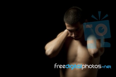 Portrait Of A Young Muscular Man Against Black Stock Photo