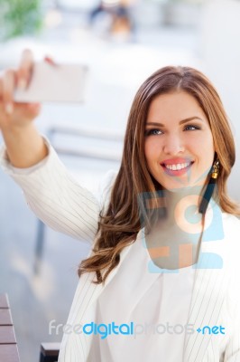 Portrait Of A Young Woman Taking A Picture With Her Cell Phone Stock Photo