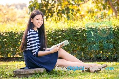 Portrait Of Asian Teen Twelve Years Old And School Book In Hand With Toothy Smiling Face Stock Photo