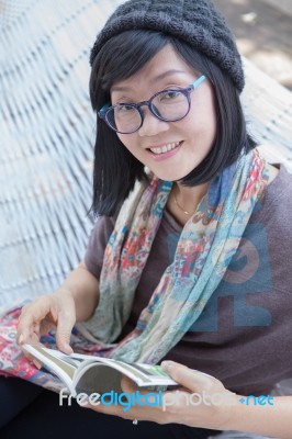 Portrait Of Beautiful Asian Woman Relaxing Time Reading Book On Cradle Happiness Emotion With Smiling Face Stock Photo