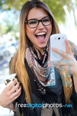 Portrait Of Beautiful Girl Drinking Coffee And Using Her Mobile Stock Photo