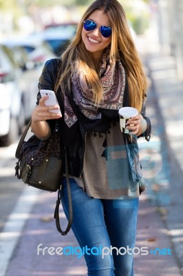 Portrait Of Beautiful Girl Drinking Coffee And Using Her Mobile Stock Photo