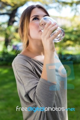 Portrait Of Beautiful Girl Drinking Water Glass At Green Park Stock Photo