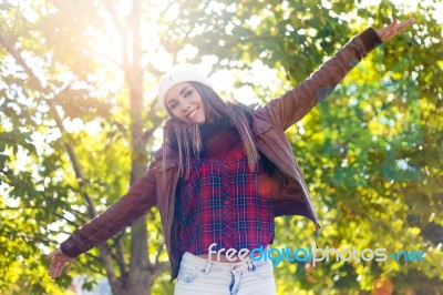 Portrait Of Beautiful Girl Standing In Autumn Field With Arms Ra… Stock Photo