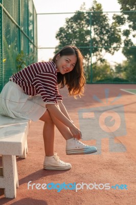 Portrait Of Beautiful Sport Girl Sitting In Tennis Courts Looking To Camera With Smiling Face Use For People And Healthy Lifestyle Activities Stock Photo