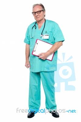 Portrait Of Grim Faced Doctor Holding A Clipboard Stock Photo