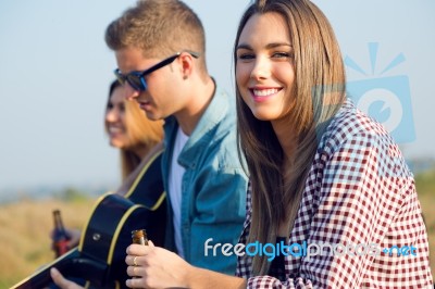 Portrait Of Group Of Friends Playing Guitar And Drinking Beer Stock Photo