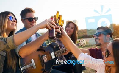 Portrait Of Group Of Friends Toasting With Bottles Of Beer Stock Photo