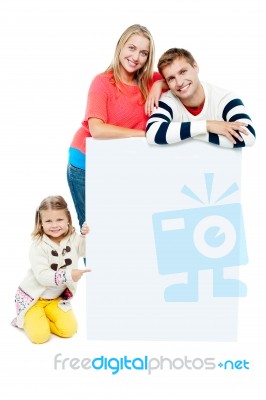 Portrait Of Happy Family Presenting Blank Whiteboard Stock Photo