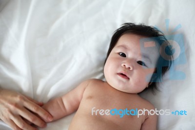 Portrait Of Newborn Baby Lying Down On A Bed, Top View Stock Photo