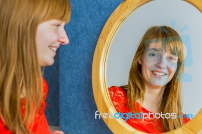 Portrait Of Redhead Girl Looking In Mirror Stock Photo