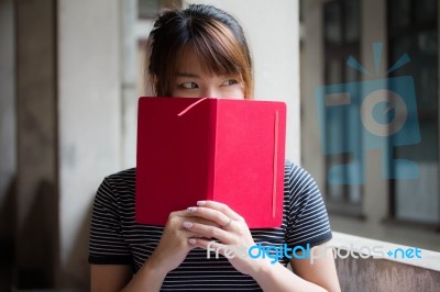 Portrait Of Thai Adult Beautiful Girl Reading Red Book Stock Photo