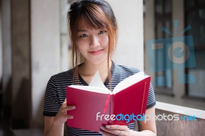 Portrait Of Thai Adult Beautiful Girl Reading Red Book Stock Photo