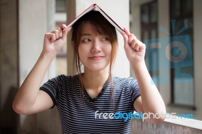 Portrait Of Thai Adult Beautiful Girl Reading Red Book Stock Photo