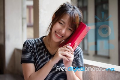 Portrait Of Thai Adult Beautiful Girl Reading Red Book Stock Photo