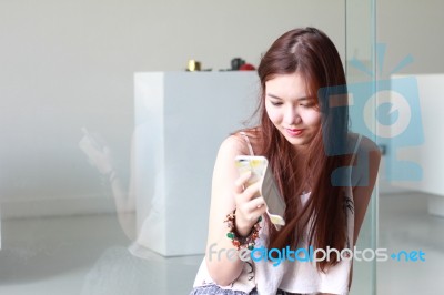 Portrait Of Thai Adult Beautiful Girl Using Her Smart Phone And Smile Stock Photo