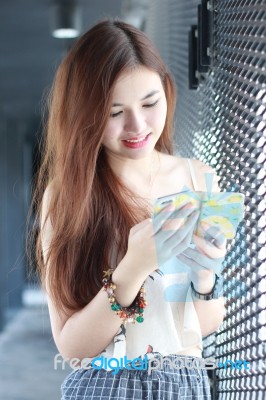 Portrait Of Thai Adult Beautiful Girl Using Her Smart Phone And Smile Stock Photo