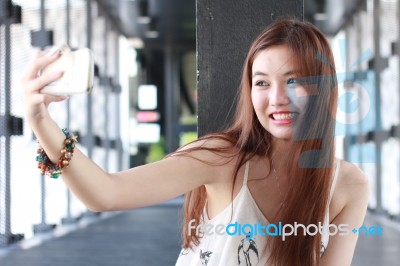 Portrait Of Thai Adult Beautiful Girl Using Her Smart Phone Selfie Stock Photo