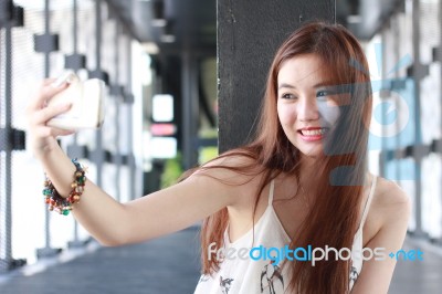 Portrait Of Thai Adult Beautiful Girl Using Her Smart Phone Selfie Stock Photo